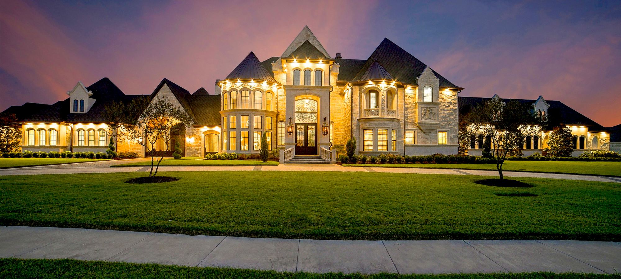Grand stone residence illuminated at dusk